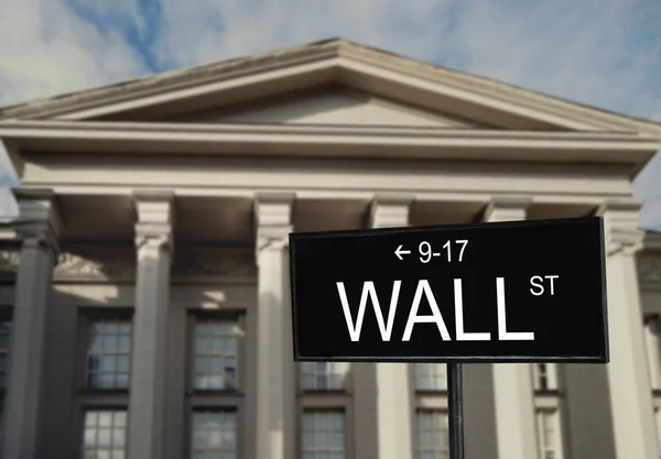 Wall Street signboard and stock exchange building on background