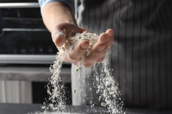 Man sprinkling wheat flour, closeup