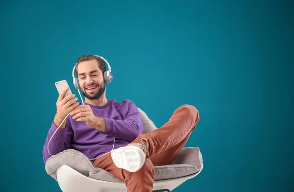 Hombre Guapo Escuchando Música Mientras Está Sentado Cómodo Sillón Contra —  Fotos de Stock