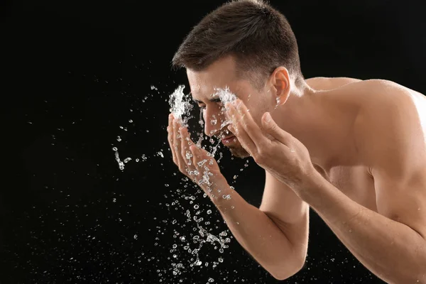 Seorang Pria Menyemprotkan Air Wajahnya Setelah Bercukur Latar Belakang Hitam — Stok Foto