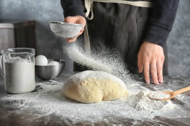 Genç kadın masada hamur üzerine un Eleme