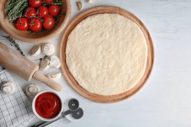 Mutfak masasında malzemelerle pizza için çiğ hamur