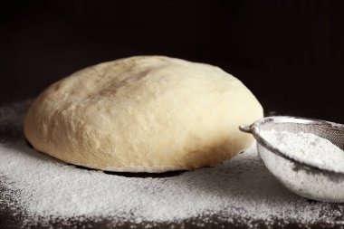 Çiğ hamur ve mutfak masasının üzerinde elek