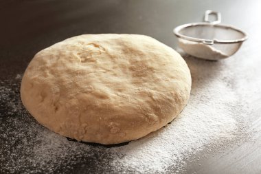 Çiğ hamur ve mutfak masasının üzerinde elek