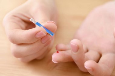 Kan şekeri kontrolü, closeup için test şeridi kullanan kadın