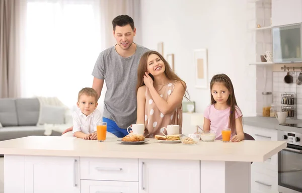 Família feliz tomando café da manhã na cozinha — Fotografia de Stock