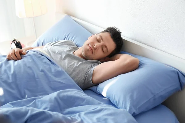 Jongeman slaapt thuis in bed — Stockfoto