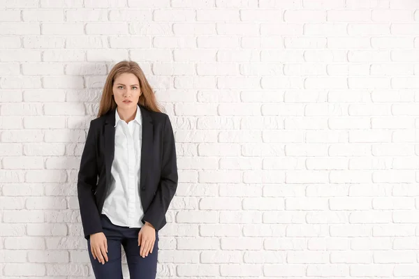 Hermosa mujer de moda en traje elegante contra la pared de ladrillo blanco —  Fotos de Stock