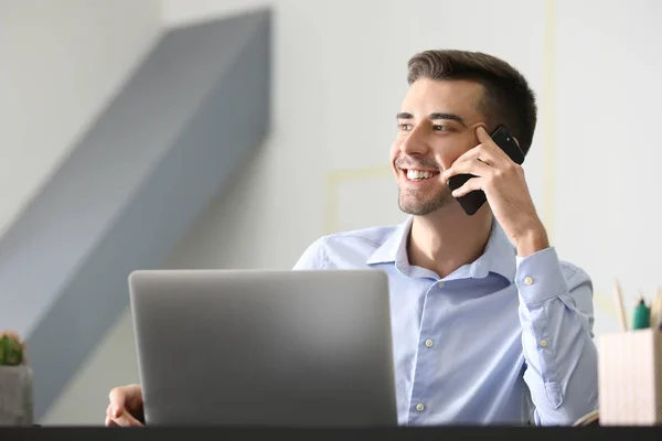 Hombre Joven Hablando Por Teléfono Mientras Trabaja Con Ordenador Portátil — Foto de Stock