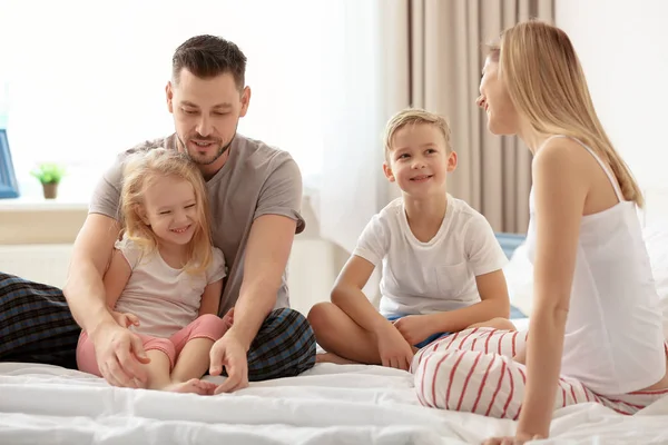 Gelukkig gezin met kinderen op bed thuis — Stockfoto