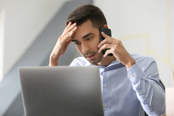 Ung Man Pratar Telefonen Medan Arbetar Med Laptop Office — Stockfoto