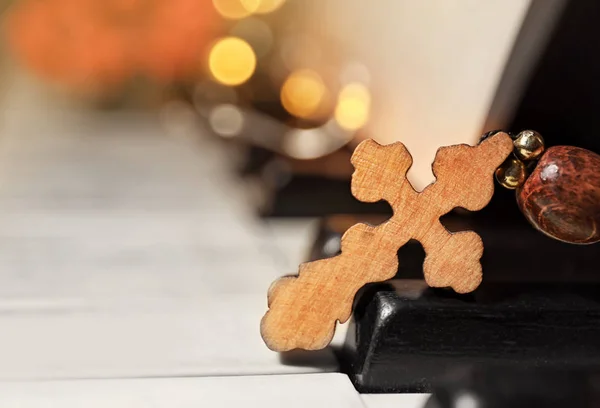 クローズ アップは ピアノの鍵盤に木製の十字架 — ストック写真