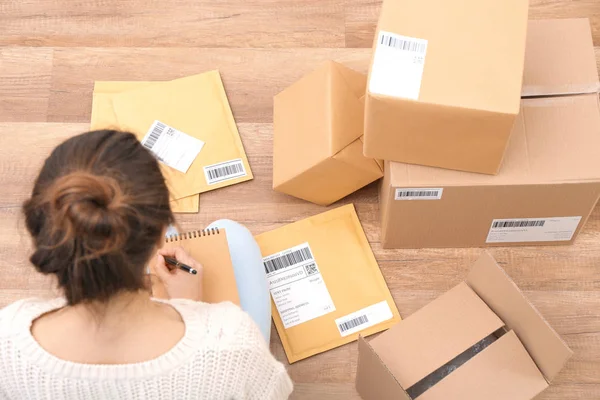 Mujer startupper preparando paquetes para el envío a los clientes en interiores — Foto de Stock