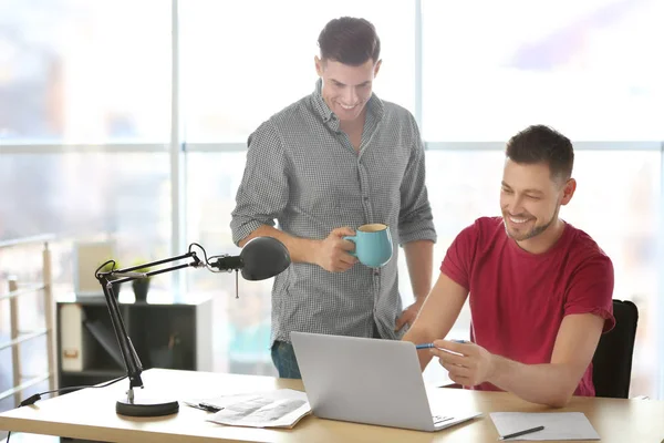 Los hombres jóvenes con portátil en el interior — Foto de Stock