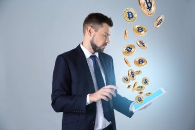 İşadamı tablet ve açık renkli bitcoins ile