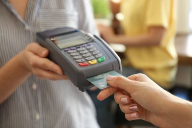 Kafede kredi kartı ödeme banka terminal kullanan kadın