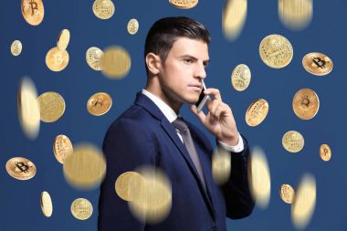 Telefon ve renk arka plan karşı düşen bitcoins konuşurken işadamı