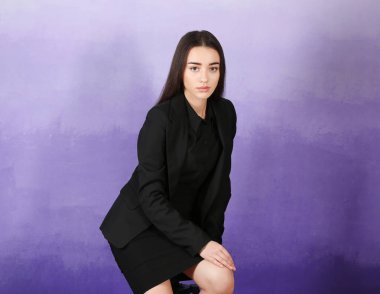 Renk arka plan üzerinde şık elbiseli güzel genç kadın