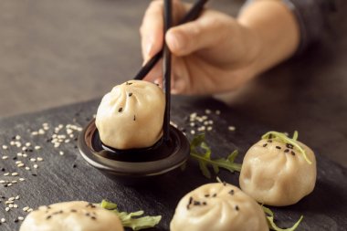 Kadın masada soya soslu lezzetli baozi hamur tatlısı daldırma