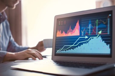 Ofiste tabloda hisse senedi verileri ile dizüstü bilgisayar. Finansal ticaret kavramı