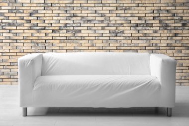 Tuğla duvar kapalı yakınındaki şık kanepe