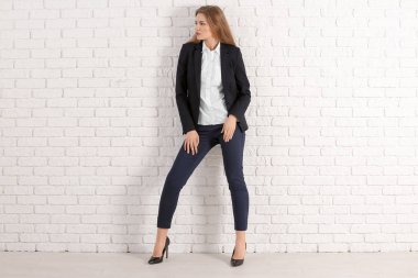 Beyaz duvara karşı şık elbiseli güzel moda kadın