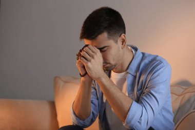 Evde dua tespih ile dini genç adam