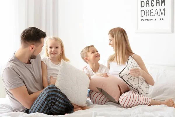 Familia feliz en la cama con almohadas suaves en casa — Foto de Stock