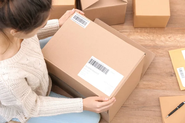 Female startupper preparing parcels for shipment to customers indoors — Stock Photo, Image