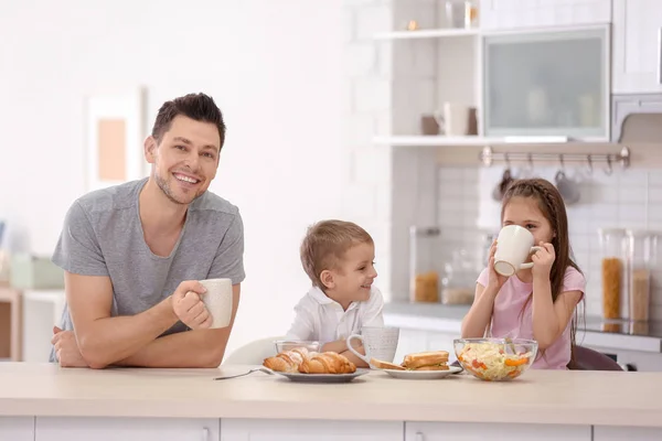 Отец с детьми завтракает на кухне — стоковое фото