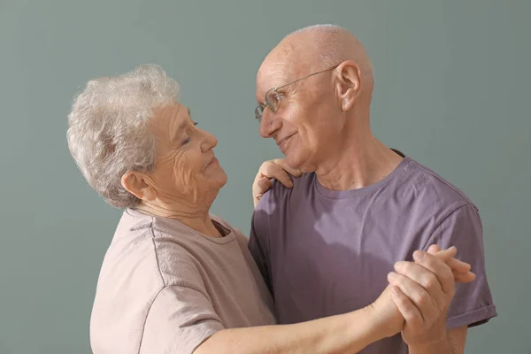 Couple âgé mignon dansant sur fond de couleur — Photo