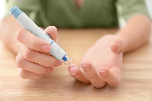 Diabetic Woman Taking Blood Sample Lancet Pen Wooden Table Closeup — Stock Photo, Image