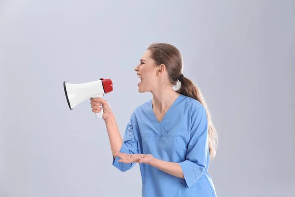 Junge Ärztin Brüllt Megafon Auf Grauem Hintergrund — Stockfoto