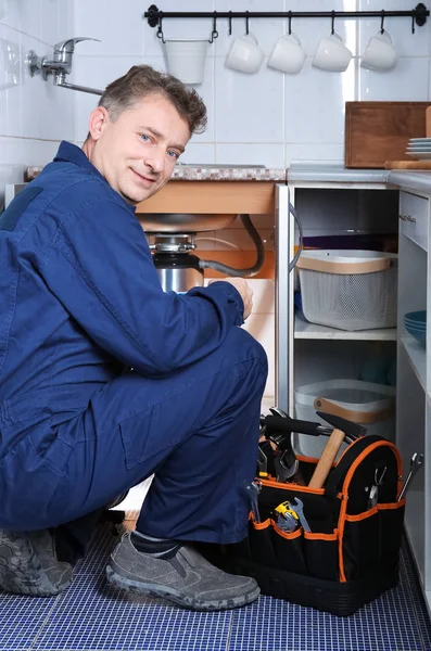 Сантехнік ремонтує раковину на кухні — стокове фото