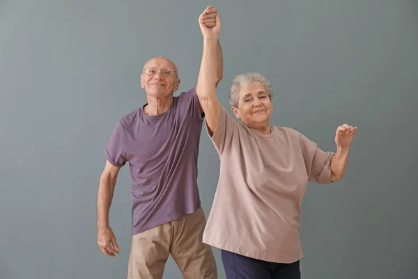 Linda pareja de ancianos bailando contra el fondo de color — Foto de Stock