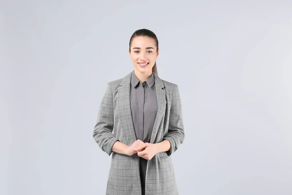 Beautiful young woman in elegant suit on light background — Stock Photo, Image