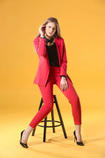 Hermosa mujer de moda en traje elegante sobre fondo de color — Foto de Stock