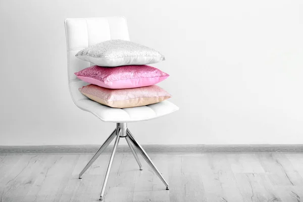 Pilha Travesseiros Cadeira Perto Parede Branca — Fotografia de Stock