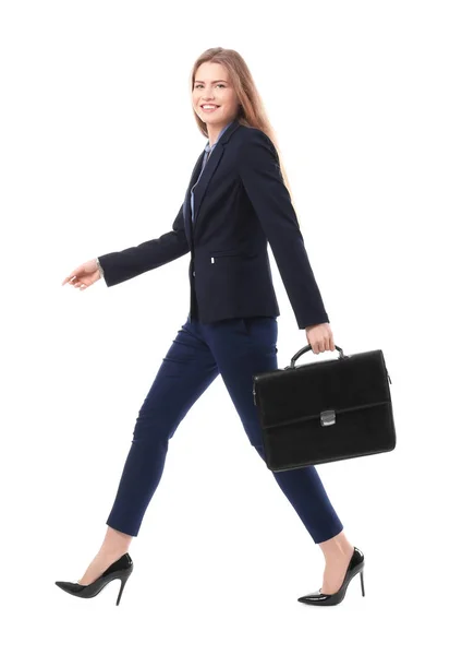 Beautiful young businesswoman in elegant suit walking against white background — Stock Photo, Image