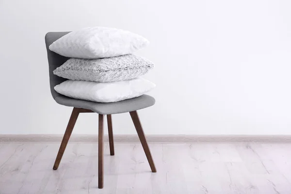 Pilha Travesseiros Cadeira Perto Parede Branca — Fotografia de Stock