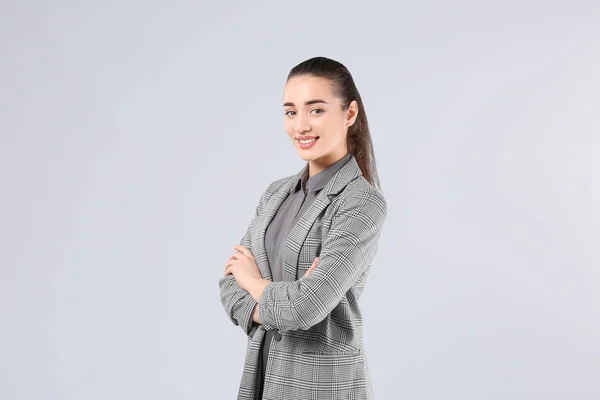 Beautiful young woman in elegant suit on light background — Stock Photo, Image