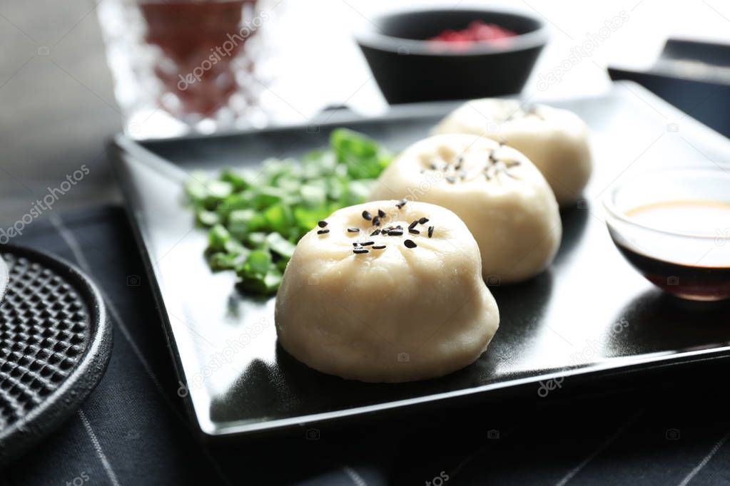 Plate with tasty baozi dumplings on table, closeup