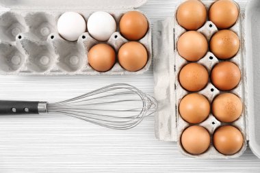 Tavuk yumurtası ve masada çırpma teli ile paketleri