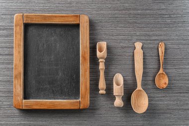 Ahşap arka plan üzerinde kara tahta ve mutfak aletleri. Ana sınıfları pişirme