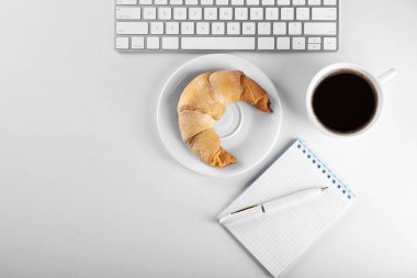 Beyaz arka plan üzerinde fincan kahve ve bilgisayar klavye ile lezzetli Hilal rulo