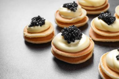 Gri arka plan üzerinde siyah havyar ile leziz kanepeler