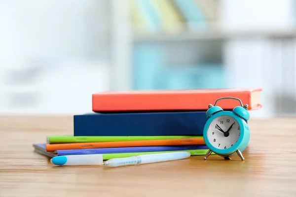 Wecker und Schulbücher auf dem Tisch. Zeit zum Lernen — Stockfoto