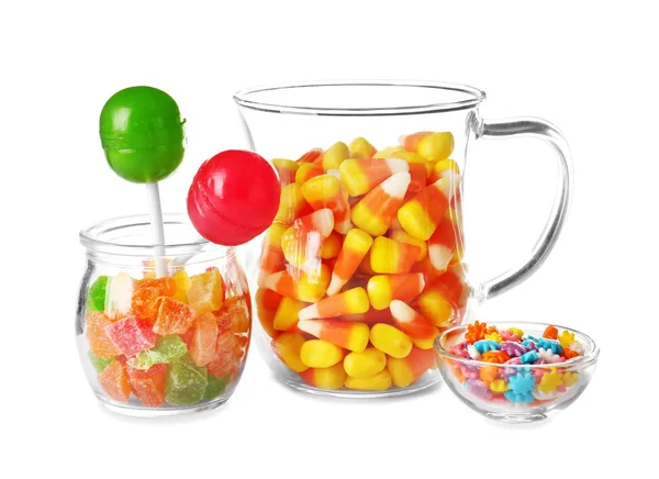 Artículos de vidrio con diferentes caramelos de colores sobre fondo blanco — Foto de Stock