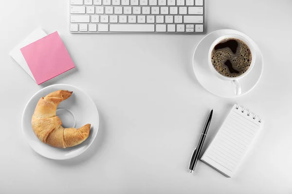 흰색 바탕에 커피와 컴퓨터 키보드의 컵과 맛 있는 초승달 모양의 롤 — 스톡 사진