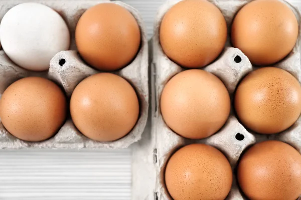 Pacchetti con uova di pollo sul tavolo — Foto Stock